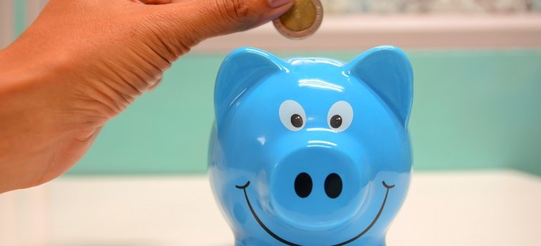 a person putting a coin in the piggy bank 