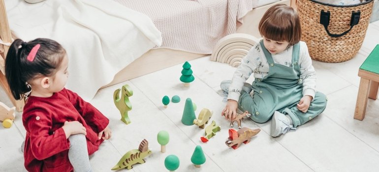 boy and girl playing with toys on the floor 